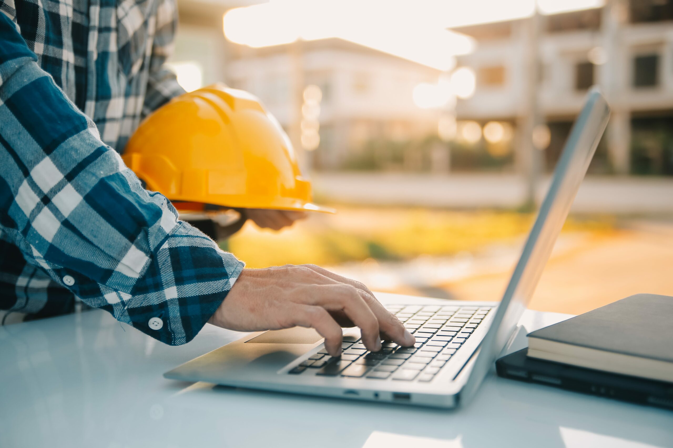 Hands-on laptop at jobsite illustrating how technology enables real-time safety training and certification tracking.