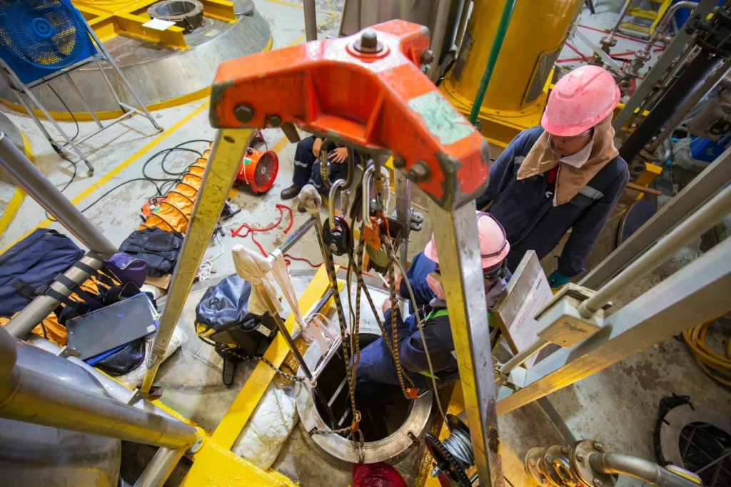 Team conducting confined space operation with approved entry and rescue system.