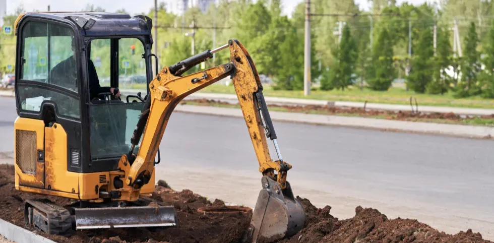 View from inside a mini excavator cab demonstrating safe trenching practices taught in mini excavator training.