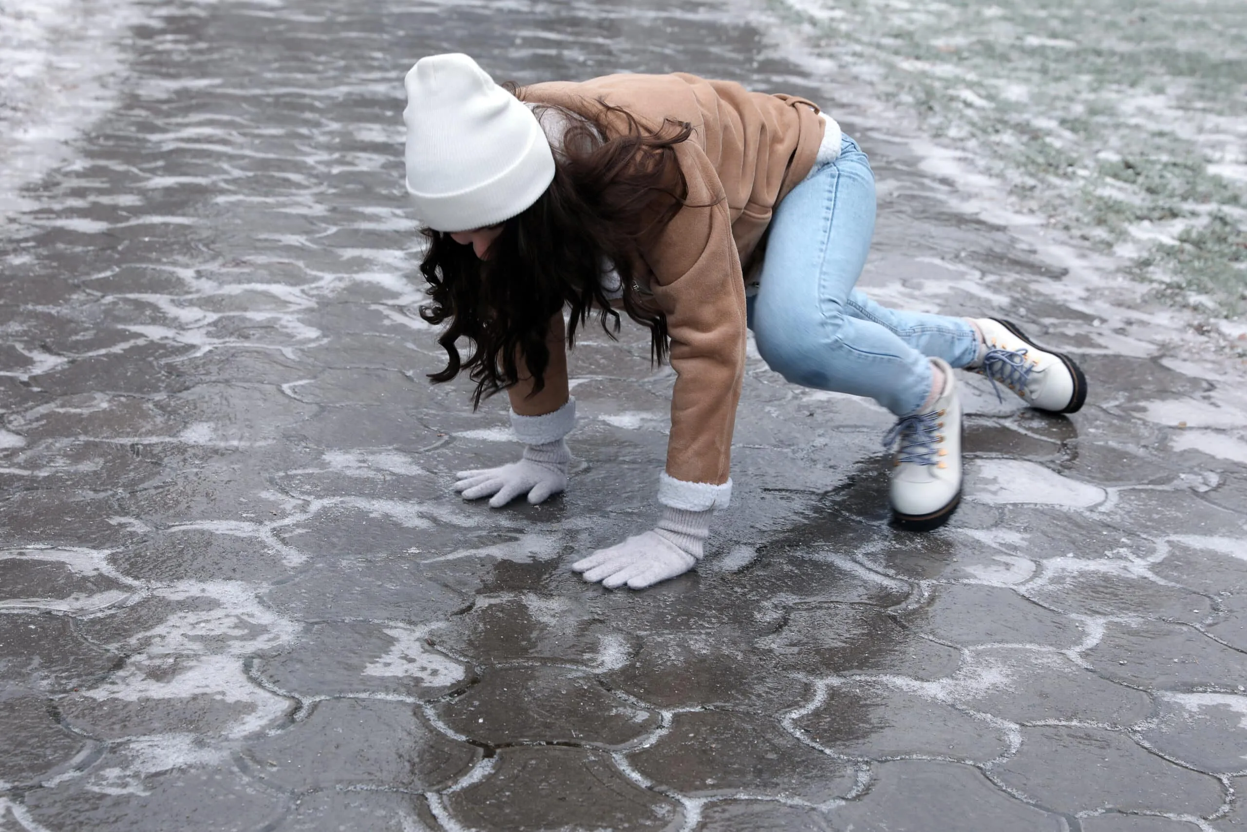 Same‑level fall on a slick surface caused by hidden ice during winter conditions.